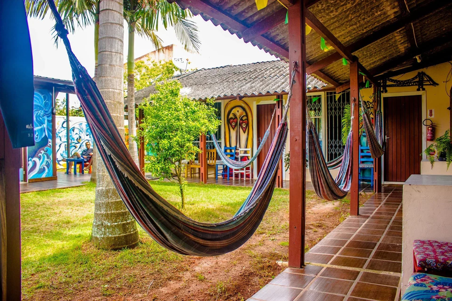Cadeiras de balanço penduradas na varanda do hostel