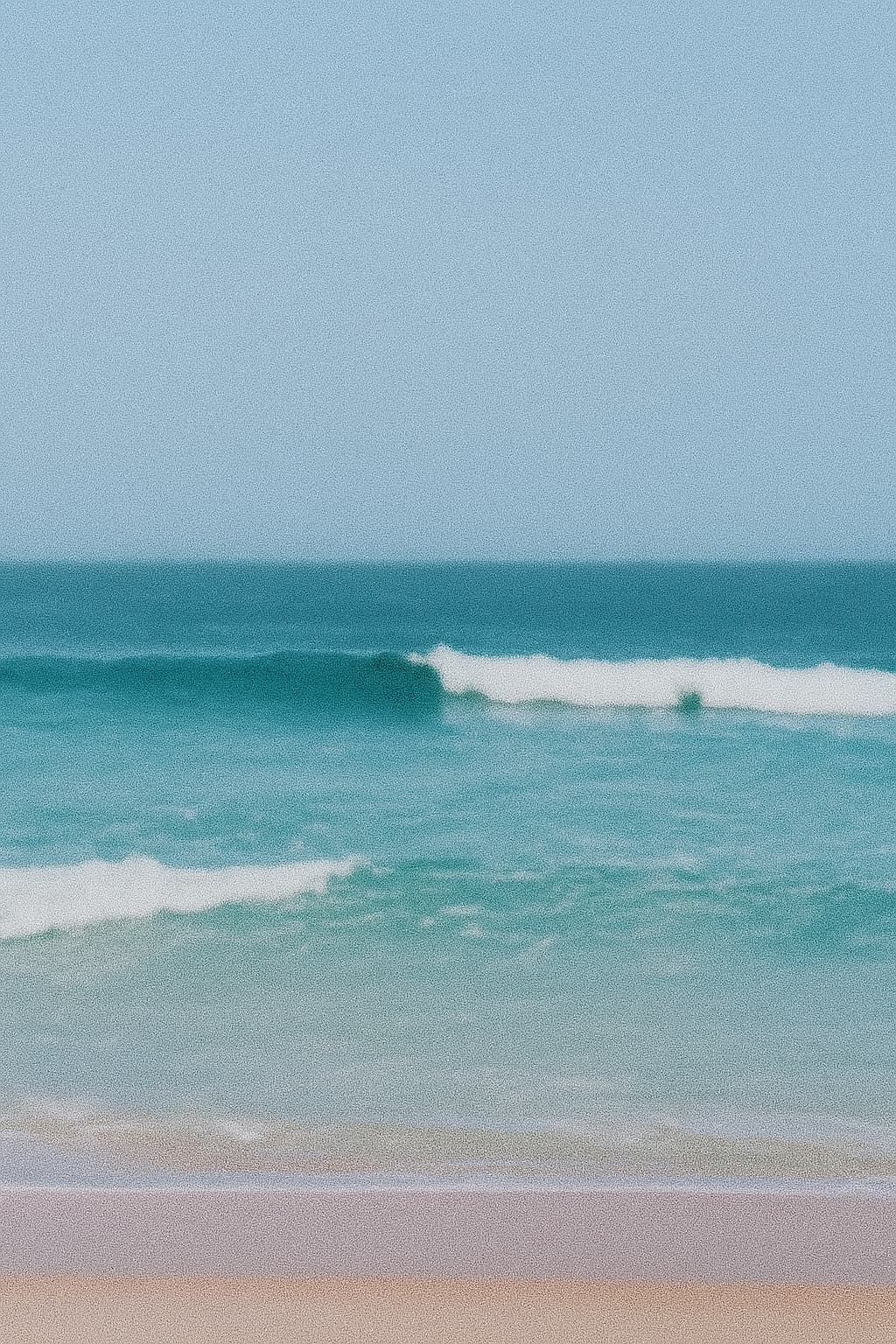 Mar de águas azuladas com ondas e céu claro no Campeche